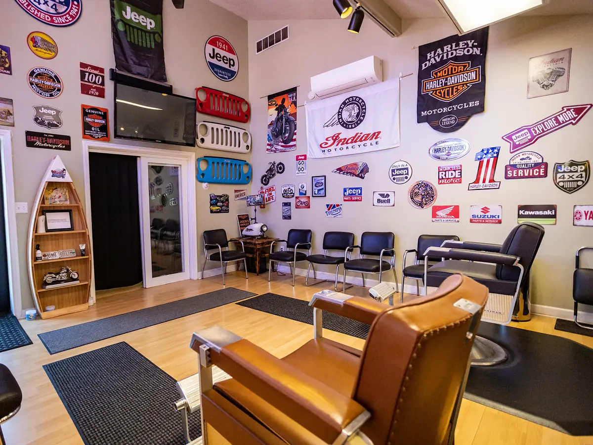 Inside The Owensboro Barbershop: a vintage leather barber chair and walls of classic motorcycle signs